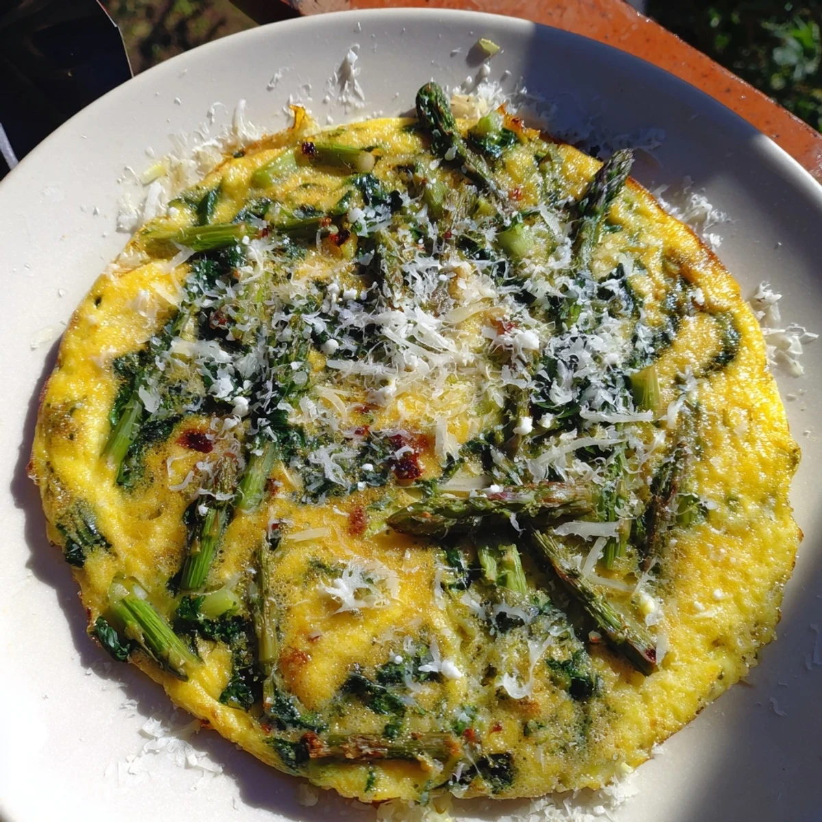 A beautiful golden Meadow-Soft Cozy Plate: Frittata with vibrant spring greens and creamy goat cheese.