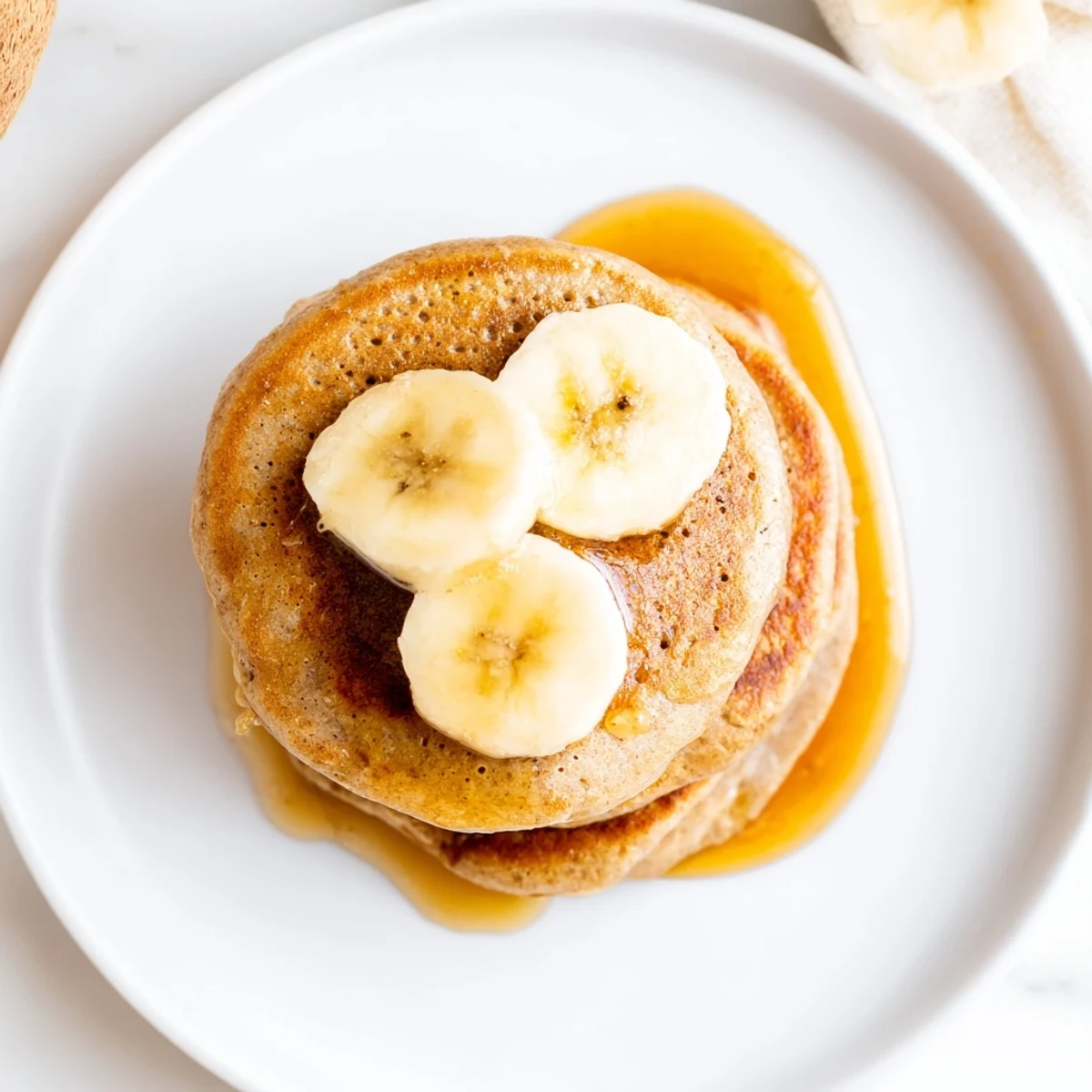 Stack of fluffy Protein Banana Pancakes, offering a hint of sweet banana, cooked with care.