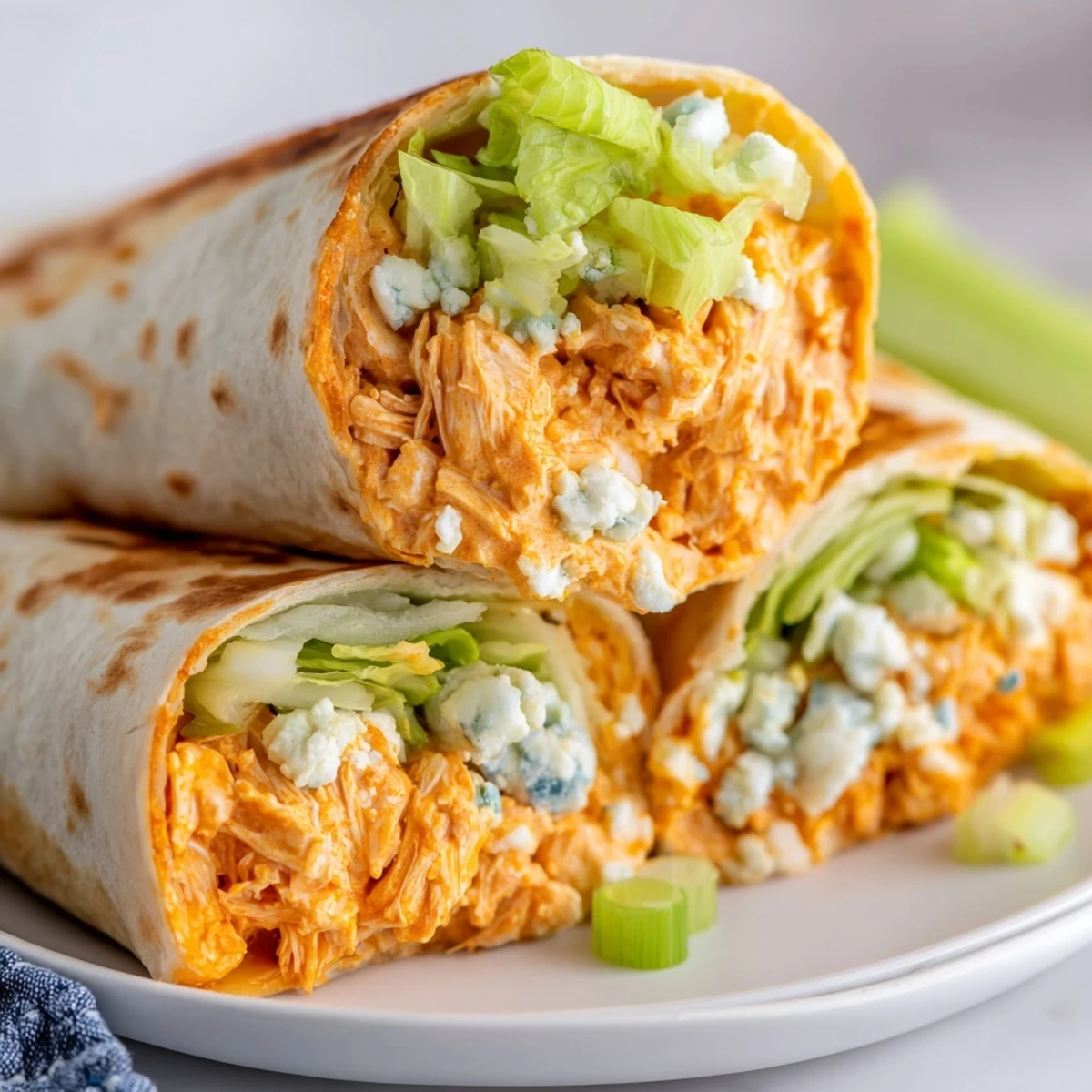 Golden-brown buffalo chicken dip wrap, boasting creamy filling and fresh romaine lettuce, ready to eat.
