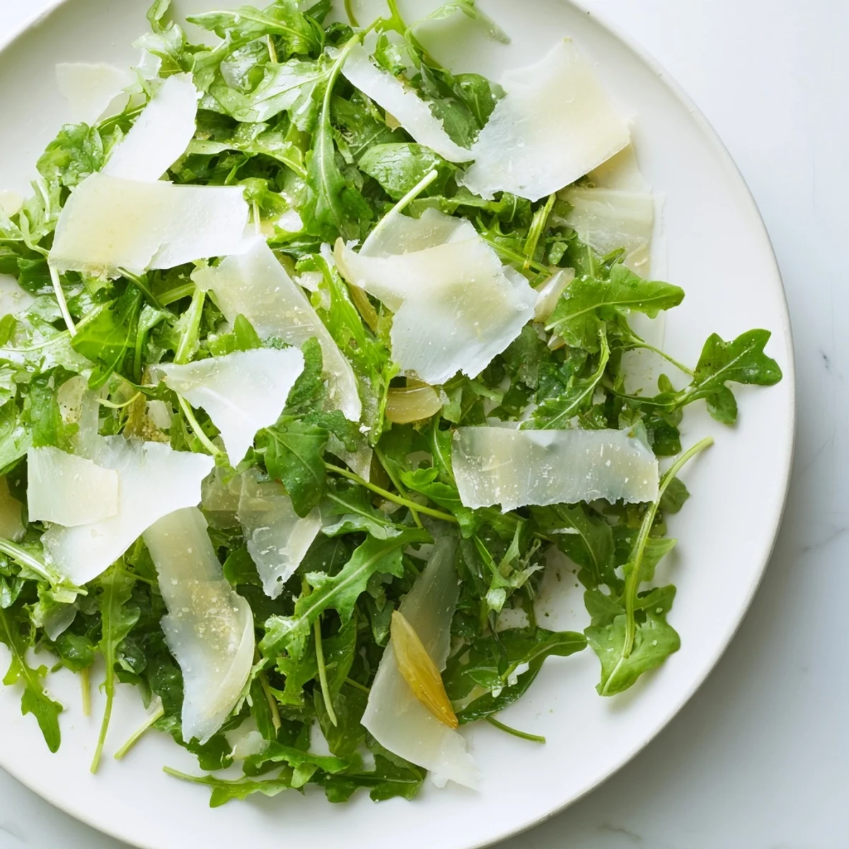 Fresh arugula salad with a bright lemon dressing, Parmesan shavings, ready to serve.