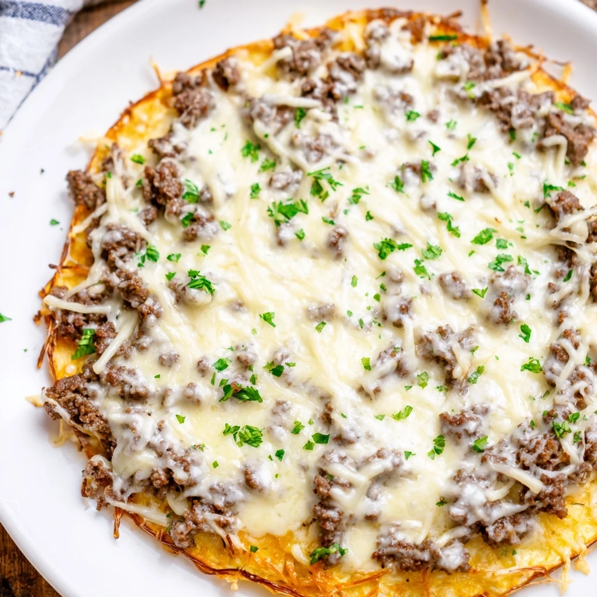 Ground Beef Alfredo Pizza: a bubbling pie with melted mozzarella and perfectly browned crust waiting to be sliced.