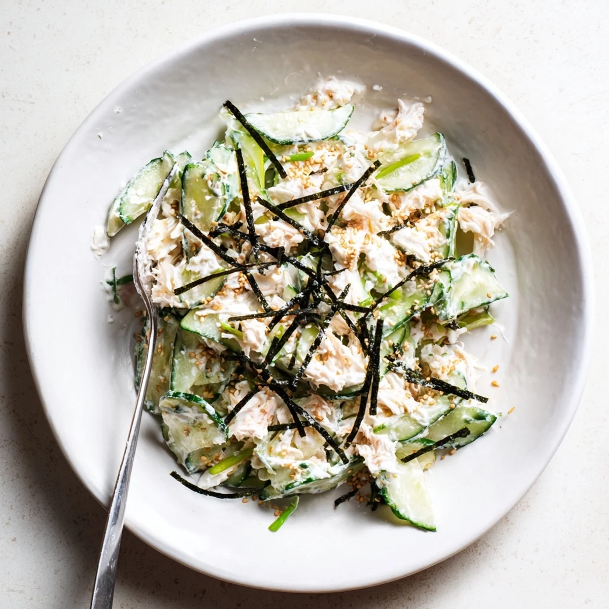Light California Roll Cucumber Salad tossed with mayo dressing and scallions, ready to serve as a refreshing appetizer.