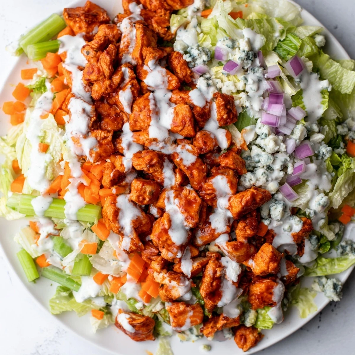 A vibrant Buffalo Chicken Chopped Salad with spicy red chicken, crisp romaine, celery, and creamy blue cheese crumbles.