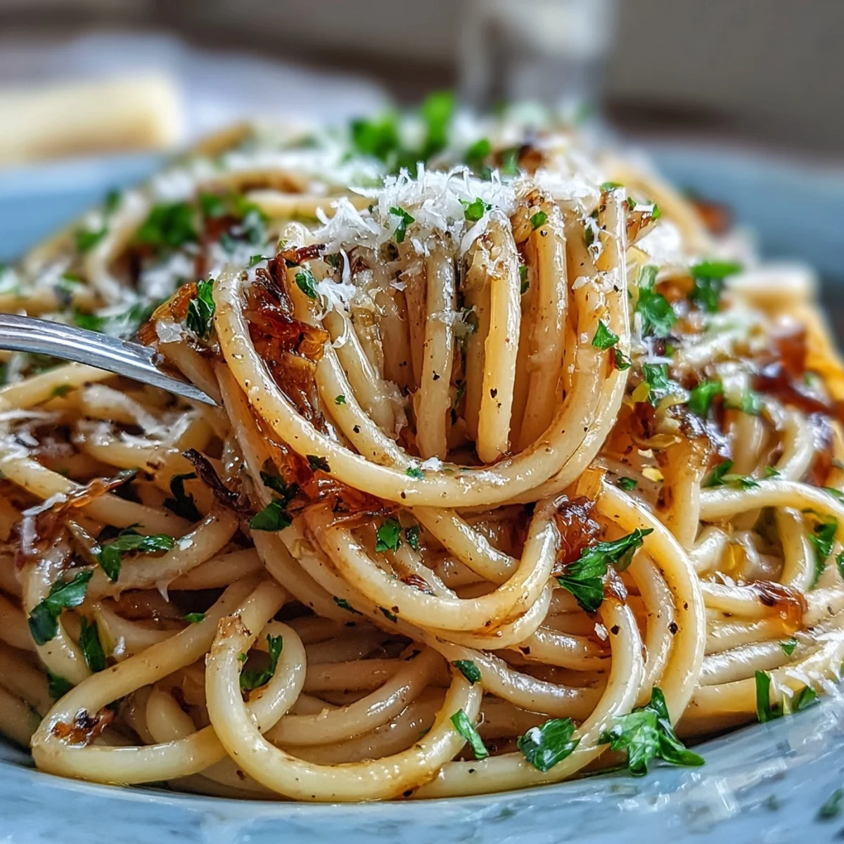 A white bowl holds steaming Cabbage Pasta With Garlic and Parmesan, flecked with parsley and lemon zest.