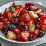 Colorful bowl of strawberry lemonade fruit salad featuring fresh strawberries, blueberries, and watermelon tossed in a tangy lemonade dressing.