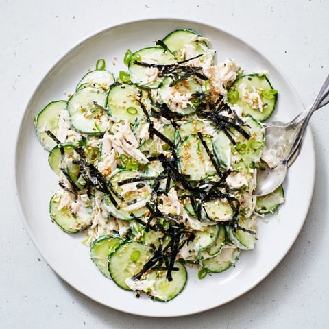 Creamy California Roll Cucumber Salad with shredded imitation crab and crisp cucumbers, garnished with sesame seeds and nori strips.