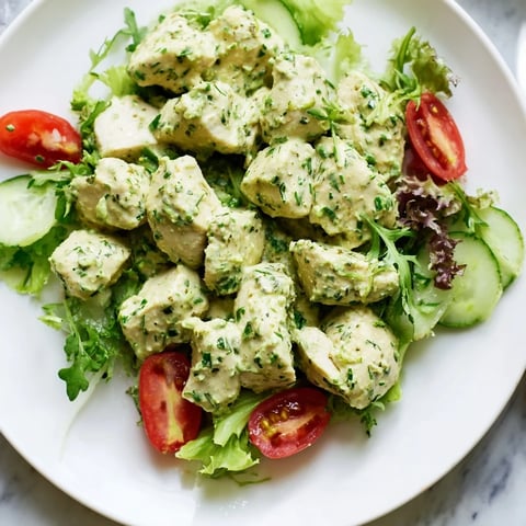 Tender baked chicken chunks coated in creamy Green Goddess dressing, mixed with crisp greens, cherry tomatoes, cucumber, and avocado slices.
