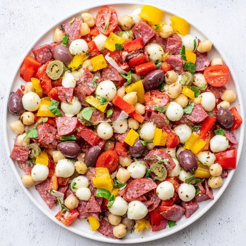 Freshly tossed Crunchy Antipasto Chopped Salad features crisp cucumbers, tomatoes, and chickpeas with salami and mozzarella pearls.