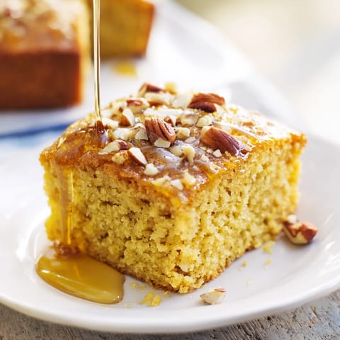 Warm golden Hazelnut and honey cake squares with a sprinkling of toasted hazelnuts, delicious aroma.