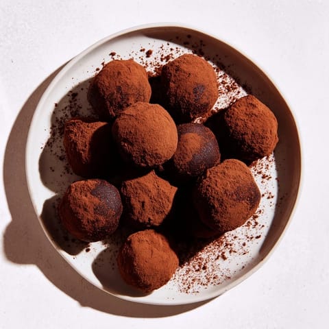 Silky dark chocolate truffles, perfect for gifting, photographed with a dusting of cocoa, ready to serve.