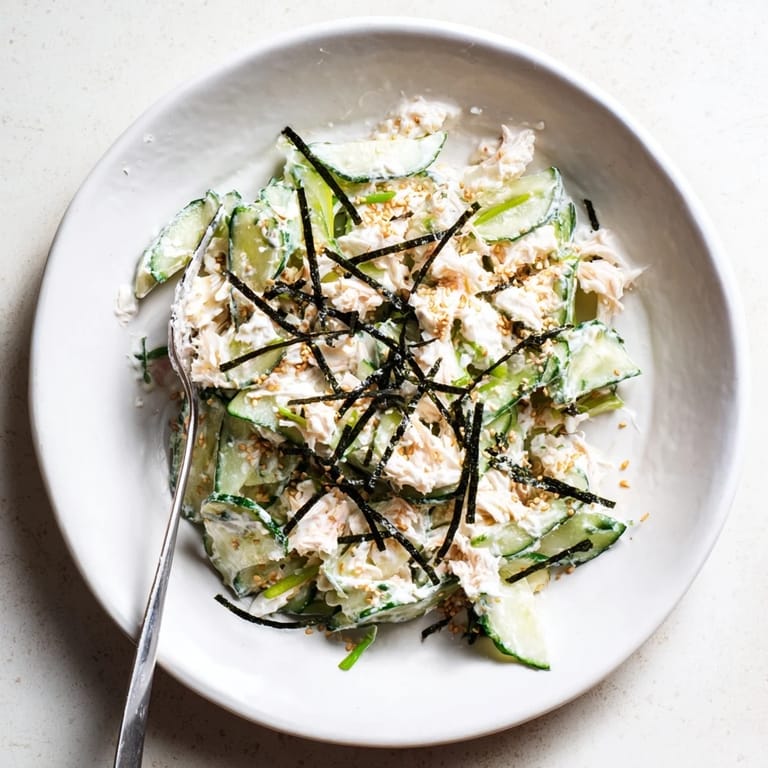 Light California Roll Cucumber Salad tossed with mayo dressing and scallions, ready to serve as a refreshing appetizer.