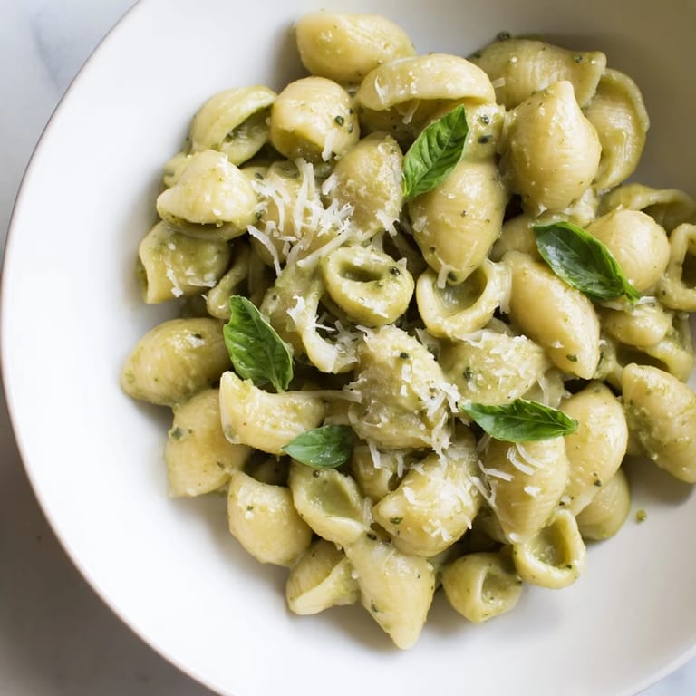 Creamy Avocado Pesto Mac served in a skillet, topped with extra Parmesan and fresh basil leaves, ready to enjoy for dinner.