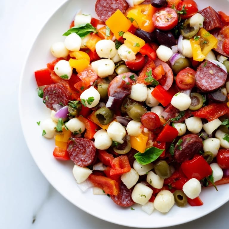 A vibrant bowl of Crunchy Antipasto Chopped Salad garnished with fresh basil and parsley, ready to serve.
