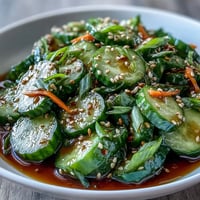 A vibrant Asian sesame cucumber salad with soy dressing, showcasing crisp cucumber slices tossed in a tangy, umami-rich sesame-soy blend.